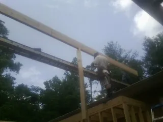 Carpenter setting a ridge beam over a new addition frame — Ice Dam Removal by Roofing Brothers in Cropwell