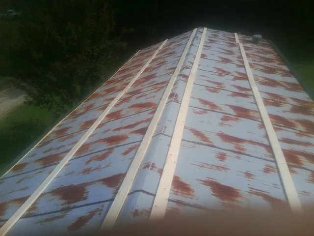 Rusted metal roof panels with new wood purlins before replacement — Storm Damage Roof Repair in Cropwell by Roofing Brothers