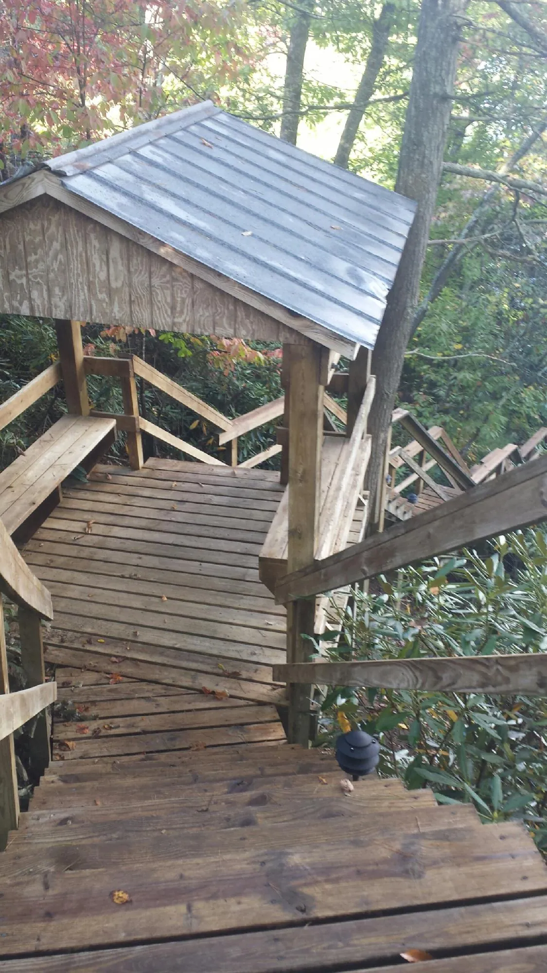 Metal roofed shelter over wooden steps on a wooded walkway — Skylight Repair & Installation work by our crew in Cropwell