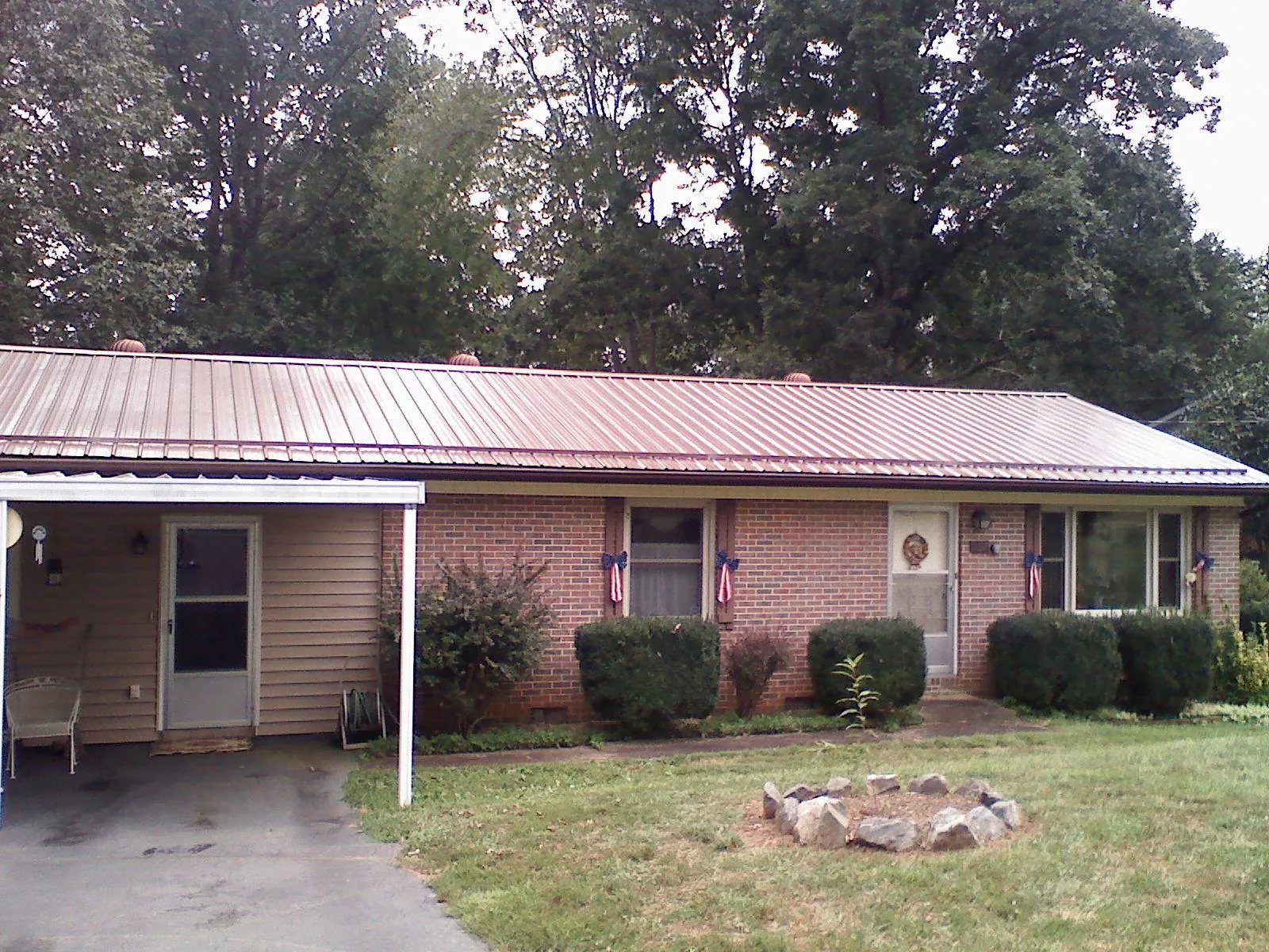 Bronze metal roof and carport on a brick ranch home — Roof Repair work by our crew in Cropwell